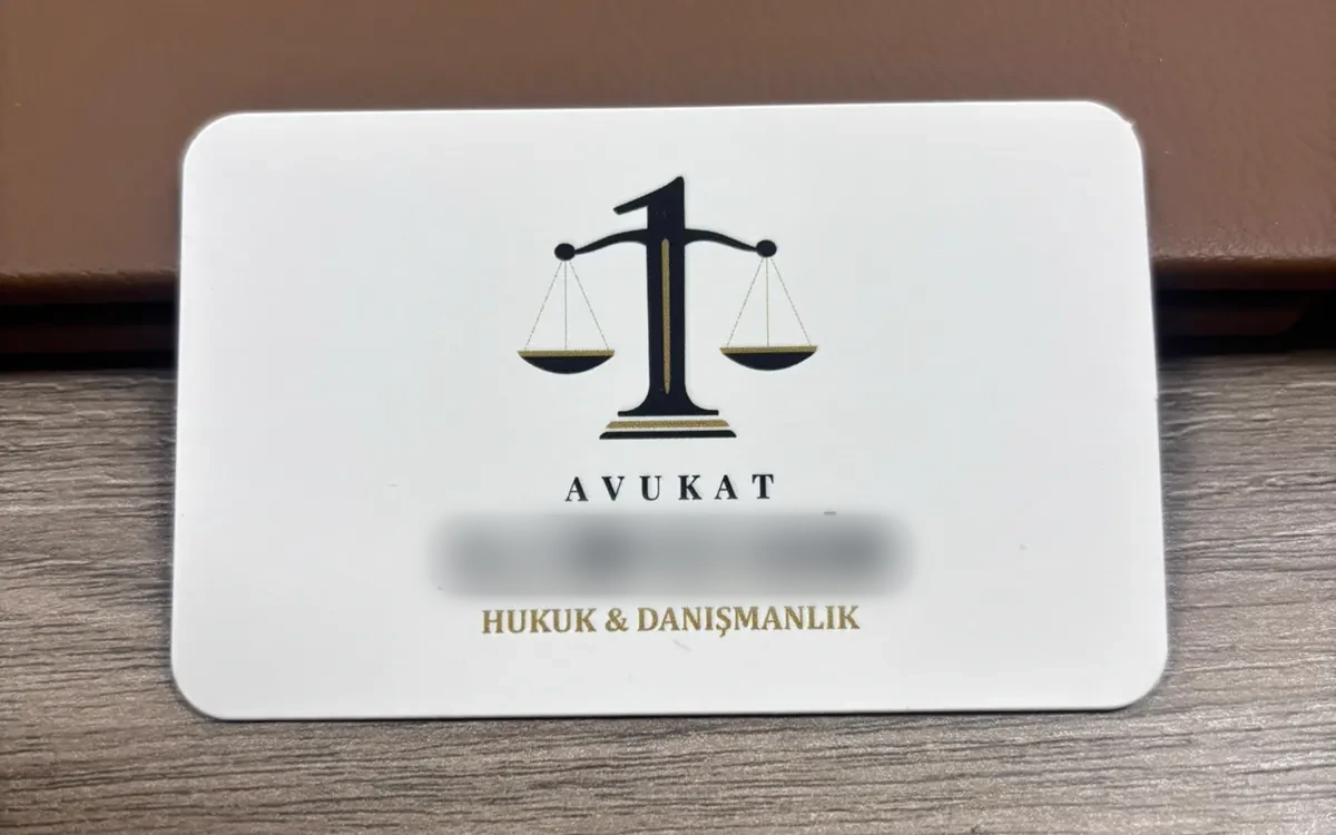 Av. A. B. kartvizitinin basılı hâli, ahşap masa üzerinde ön yüz